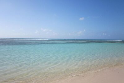 Plage de sable blanc et eaux turquoise, idéale pour une Croisière Caraïbes.