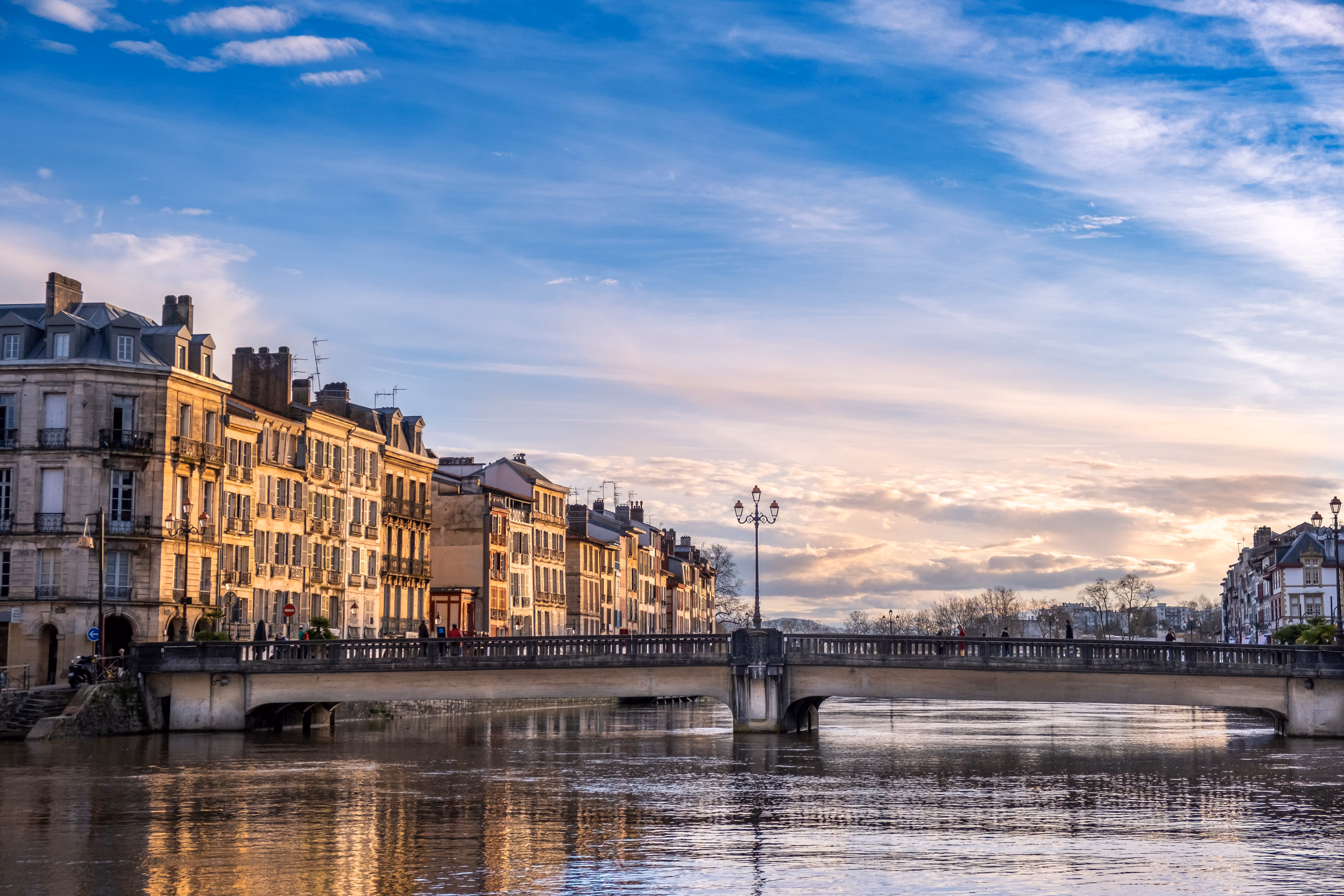 Vue de Bayonne au coucher du soleil avec pont sur la Nive, ville étape pour les services VTC Pays Basque